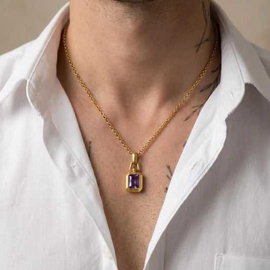 Close-up view of a handcrafted amethyst birthstone pendant necklace with 18k gold plating over sterling silver, highlighting the polished geometric pendant design and deep purple gemstone clarity