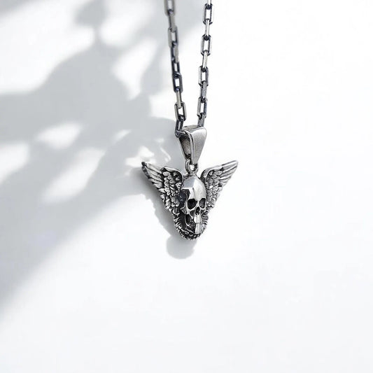 This handcrafted sterling silver gothic skull necklace features a mesmerizing skull motif with wide, detailed wings that stretch across the pendant, symbolizing both rebellion and spiritual freedom. Perfect for fans of rocker fashion, alternative style, and occult symbolism, this necklace makes a dramatic fashion statement while also serving as a protective talisman. The oxidized finish highlights every carved detail