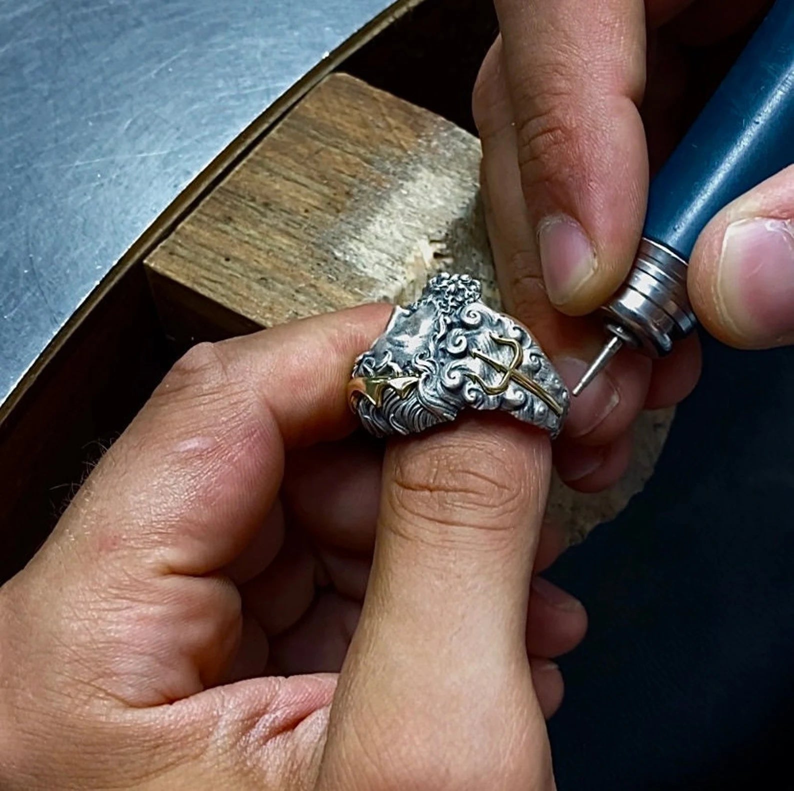 An exceptional silver and gold ring created for men who connect with the power, mystery, and mythology of the sea. Featuring Poseidon, ruler of the oceans, this bold ring is forged from 925 sterling silver and adorned with rich 14K gold, giving it both substance and shine. Its large, intricately detailed face and thick, weighty band provide a dramatic look that makes a statement wherever it’s worn.