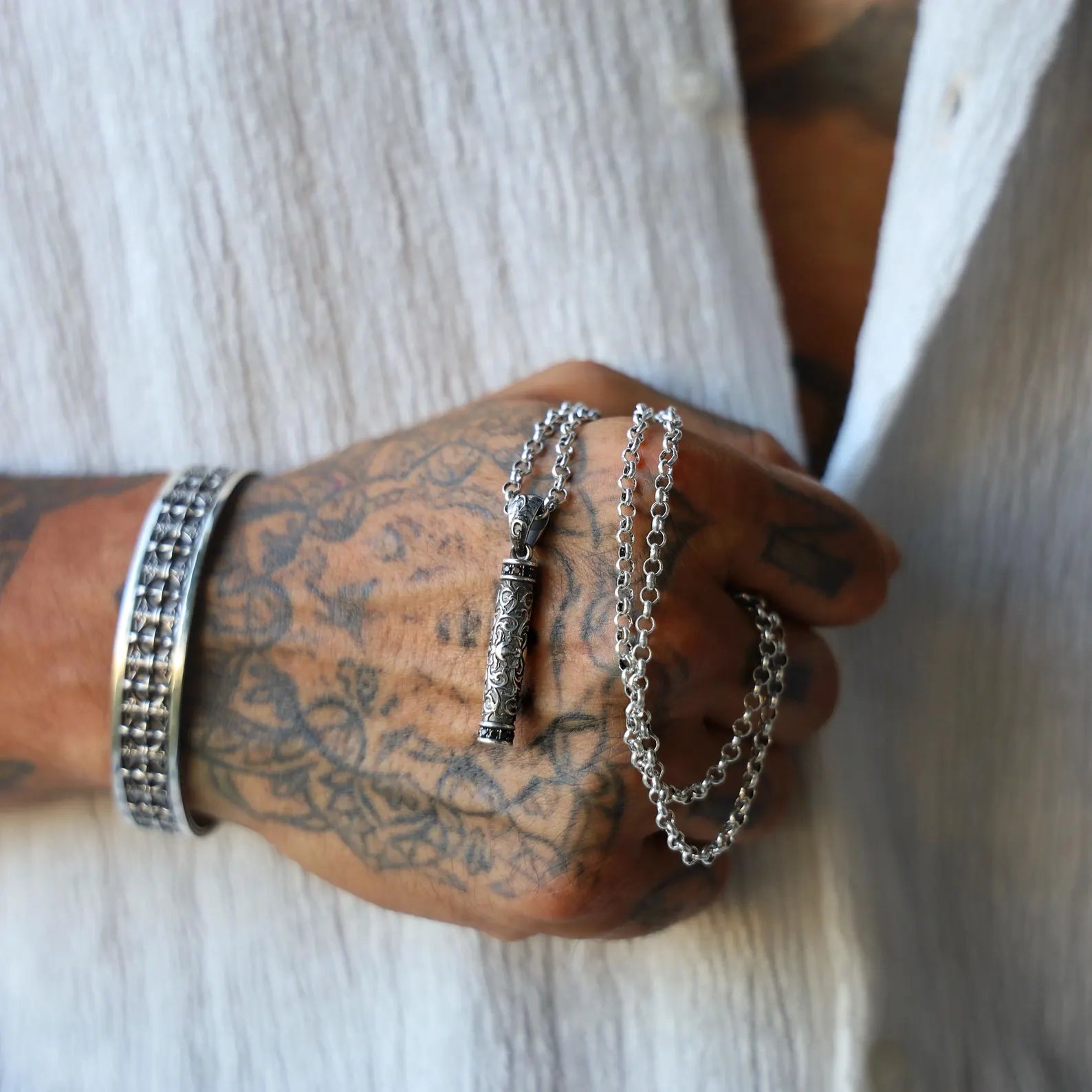 Unisex gothic silver necklace with floral bar pendant. Handcrafted in sterling silver with vintage aesthetics, this cylinder charm offers a bold yet elegant look. A perfect gift for him or her. Ideal for Pinterest pins about handcrafted jewelry and Instagram posts on gothic fashion.