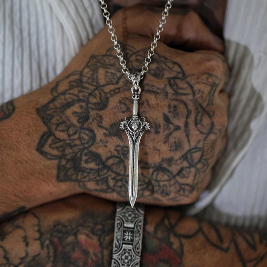 A striking gothic sword necklace made of high-quality 925K silver, featuring a leon head and fine blade engravings. This handcrafted pendant is perfect for men who appreciate symbolic, medieval-themed jewelry with elegance and edge.