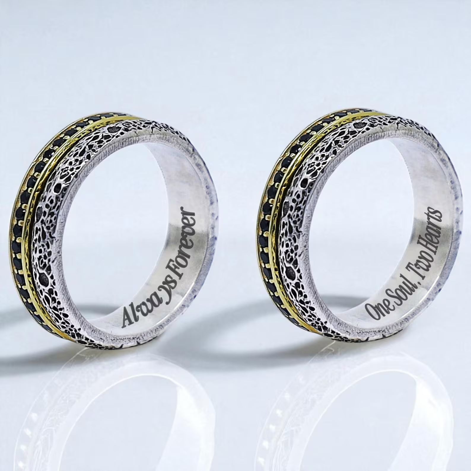 Close-up of the inner engraving and dual-tone design of the rings, capturing the meaningful inscriptions and bold visual contrast between the blackened texture and golden accents. A stunning expression of eternal love and shared soul.