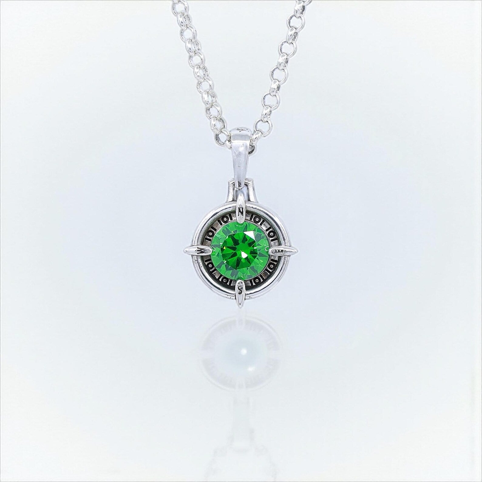 Handmade sterling silver compass necklace with a brilliant emerald green gemstone at the center. This nautical pendant symbolizes direction, guidance, and adventure. A meaningful jewelry gift for men and women who love traveling, sailing, or exploring. Perfect birthday or anniversary gift for those seeking unique handmade gemstone jewelry.