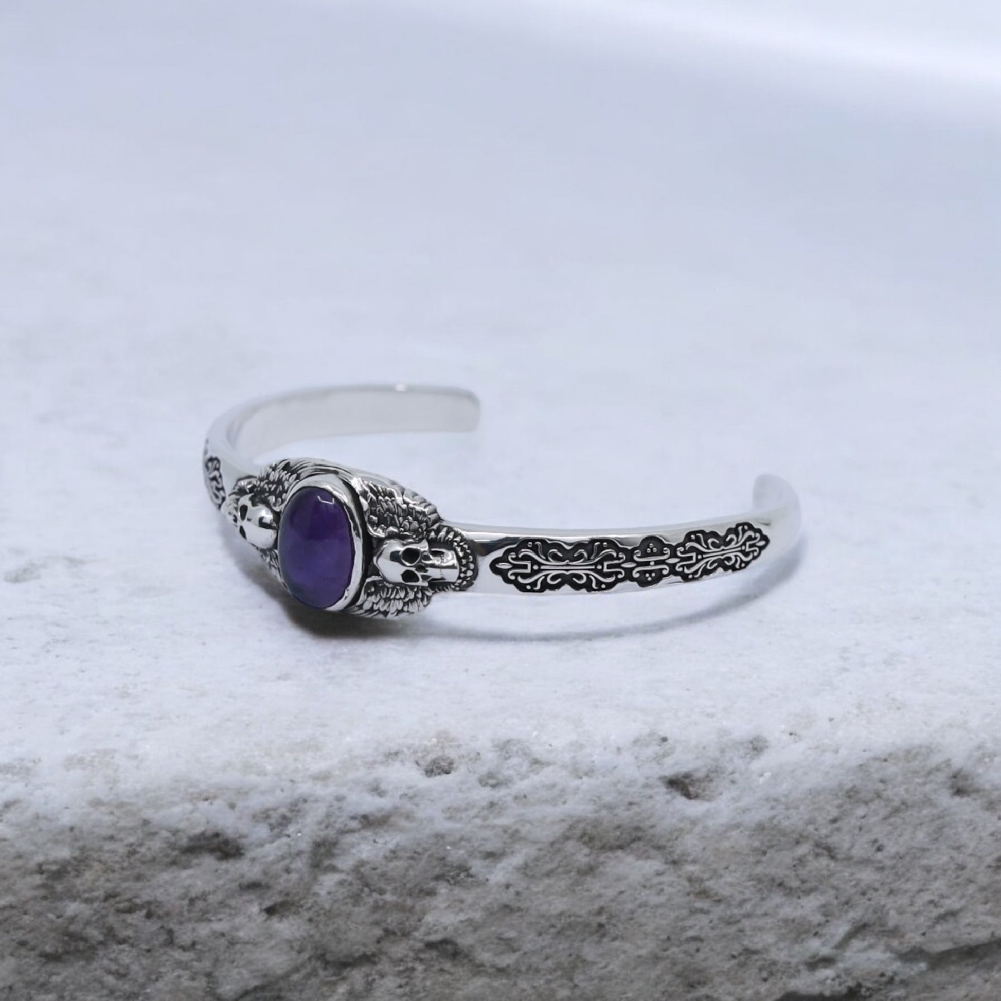 Luxury 925 sterling silver cuff bracelet with amethyst gemstone, handmade with twin skull engravings and intricate detailing. Perfect for collectors of artisan silver jewelry and lovers of gothic, vintage, and biker aesthetics.