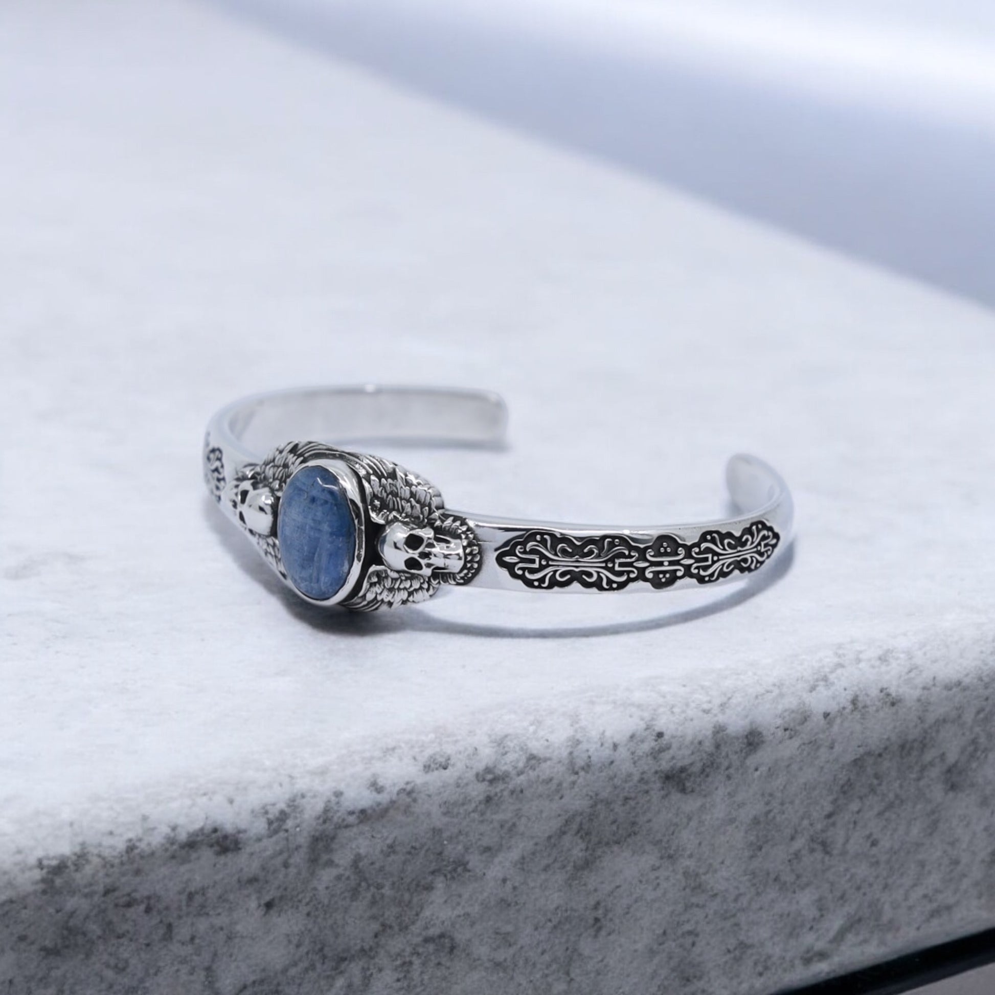 Luxury men’s sterling silver bracelet with gothic skull motifs and natural blue kyanite stone centerpiece. Perfect gift for him, whether for an anniversary, birthday, or special occasion. The handcrafted detail reflects authentic artisan jewelry.