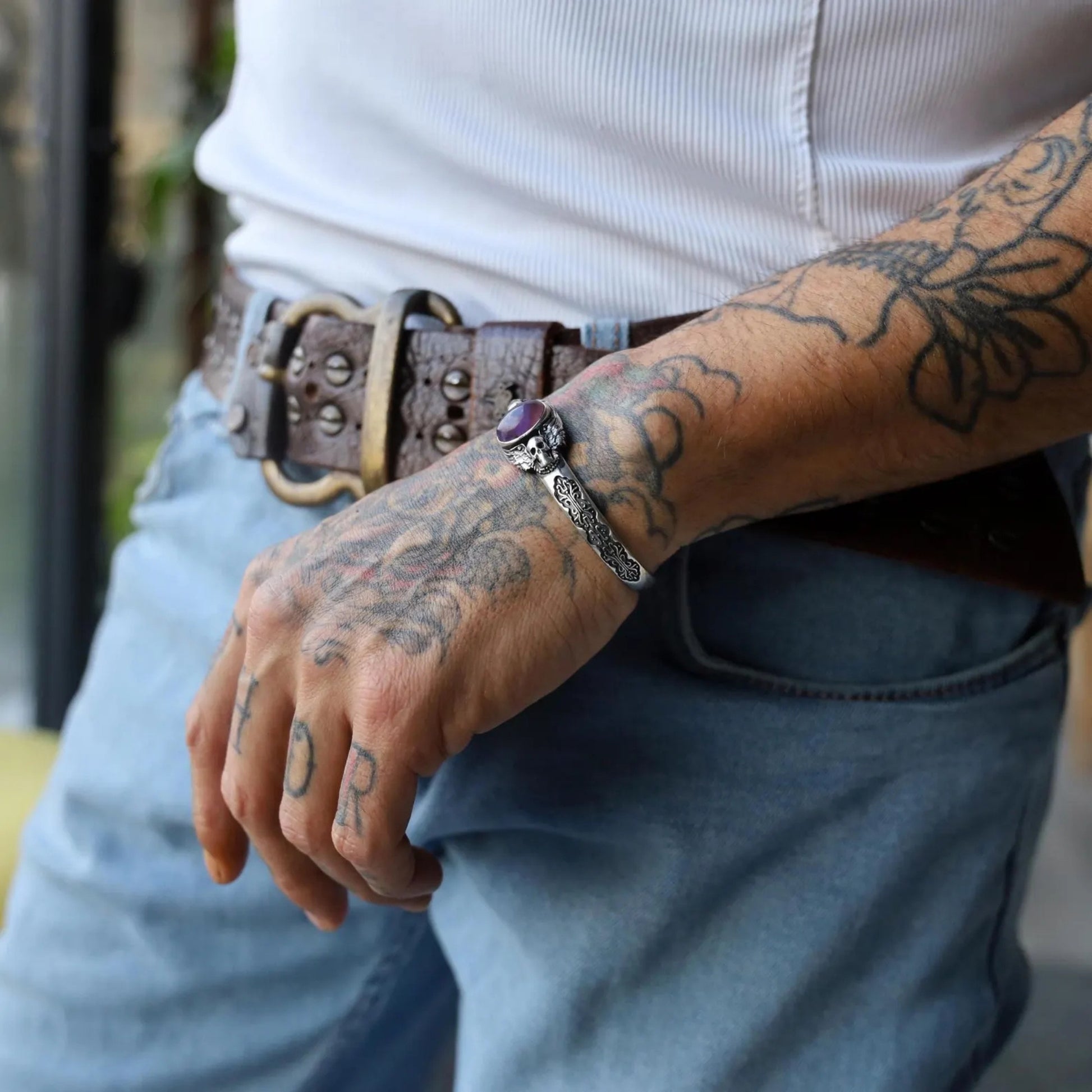 Macro image highlighting the handcrafted silver skull bracelet with amethyst stone, showcasing fine details of the oxidized silver surface and realistic skull design. Symbolizing wisdom and strength, it’s a bold piece for confident men.