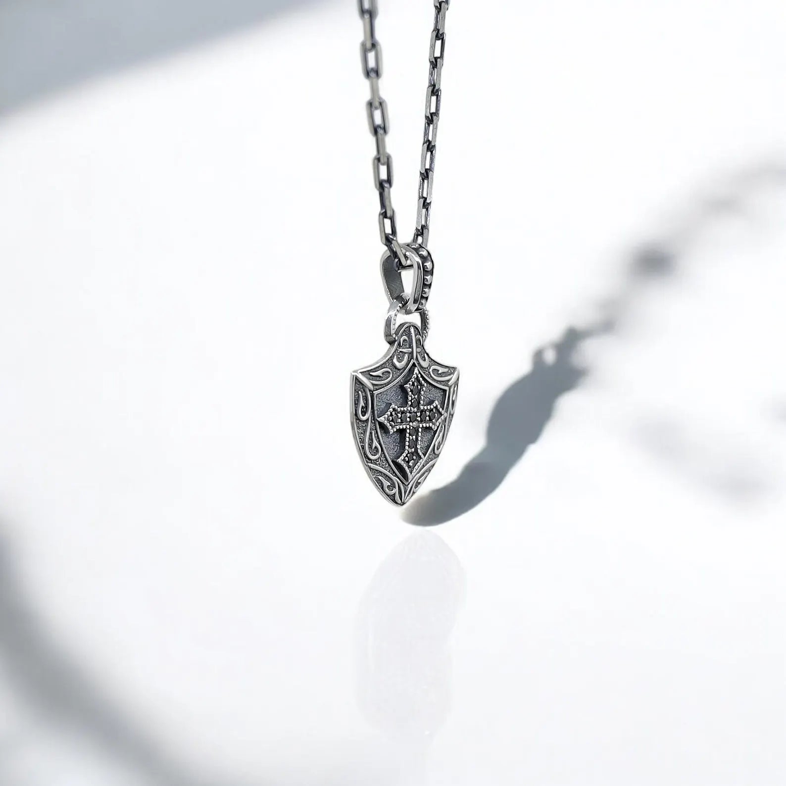 Sterling silver Gothic cross pendant necklace with a medieval shield silhouette, combining dark elegance and vintage armor design. A bold fashion statement for alternative style lovers, this necklace offers deep symbolism and artisan craftsmanship in one powerful piece.