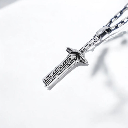 Handcrafted sterling silver sword pendant featuring medieval engravings and bold craftsmanship, symbolizing protection and strength in a powerful talismanic design that appeals to lovers of warrior aesthetics and Gothic fashion.