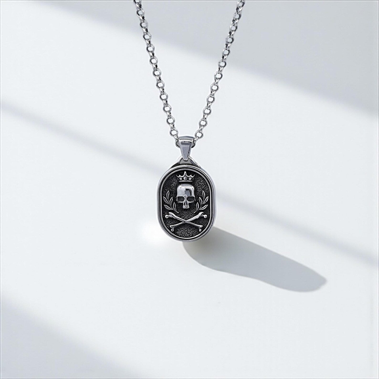 Close-up image of a men's gothic skull pendant necklace, handcrafted in sterling silver and featuring a detailed crowned skull design with crossed bones, perfect for biker style and bold gothic fashion lovers.