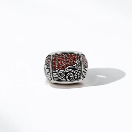Handcrafted sterling silver men's ring featuring a vivid red ruby zircon gemstone and intricate ocean wave detailing. This nautical-inspired statement piece is ideal for those who appreciate sailor aesthetics, surfer fashion, and coastal symbolism in jewelry. A bold gift option that embodies strength, freedom, and maritime heritage.