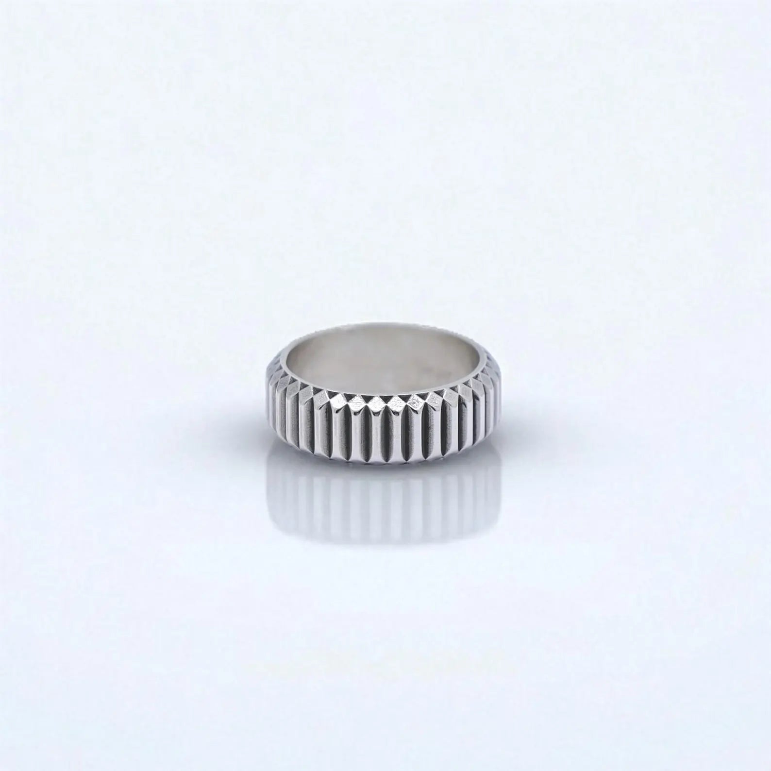 Modern mens sterling silver band ring photographed in natural light with shadow play highlighting its detailed geometric pattern. This artisan-made ring features a bold, structured surface and is suitable as a personalized gift for husbands, boyfriends, or dads with a taste for contemporary jewelry.