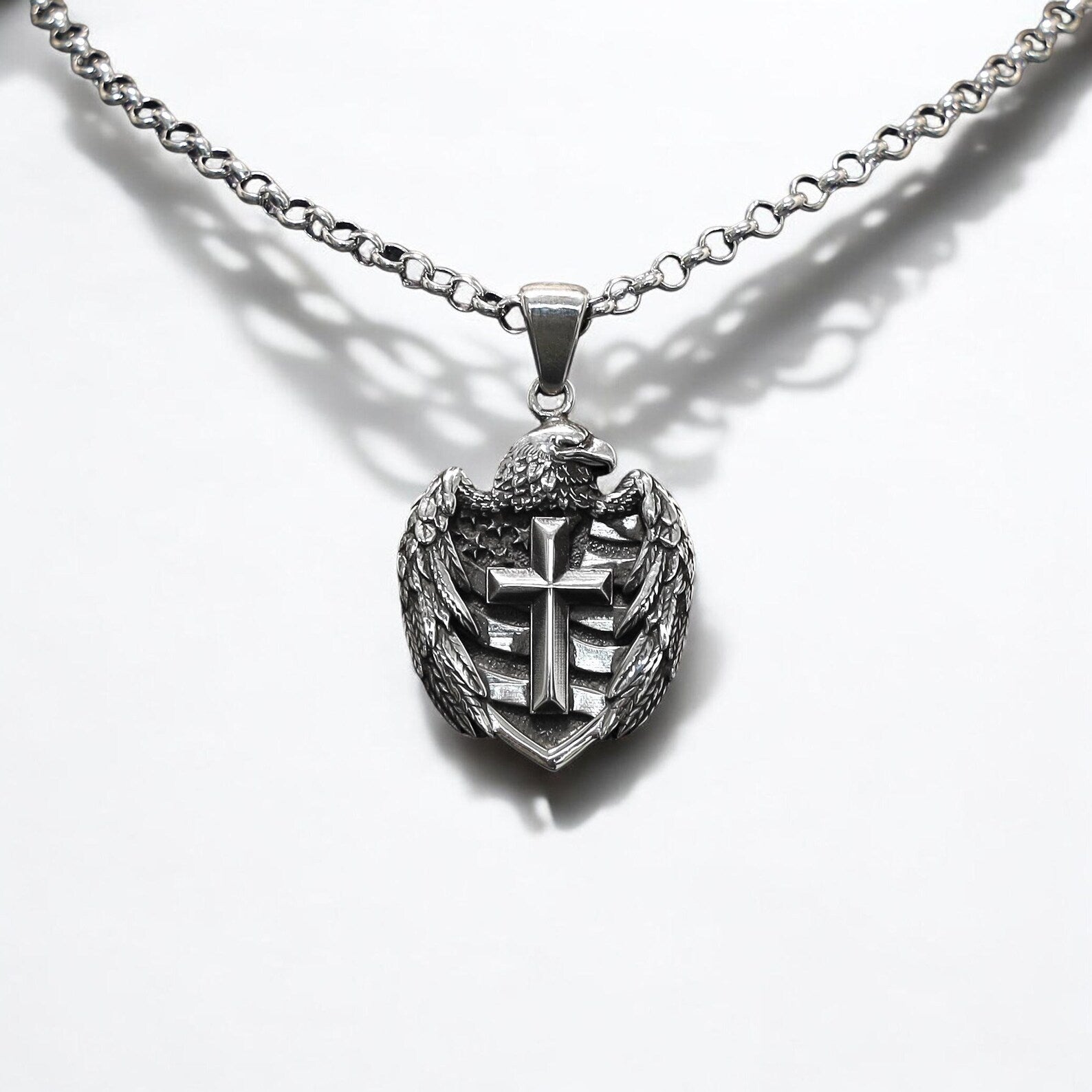 A handcrafted sterling silver cross pendant featuring a bold American eagle motif, symbolizing strength, freedom, and faith. This gothic-style patriotic necklace is a powerful statement piece designed for men who value tradition, national pride, and detailed artisan craftsmanship.