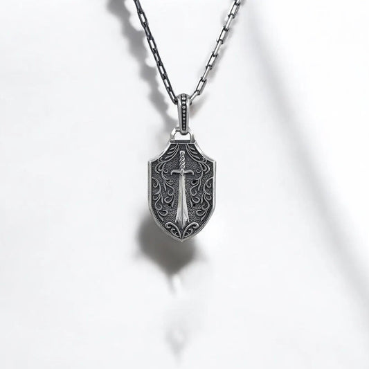 Gothic skull necklace with crowned red eye skull design on the front and sword engraving on the back, crafted from solid sterling silver. This handmade necklace is a wearable piece of art that reflects both dark beauty and inner strength, ideal for engraved gifts and personal keepsakes.