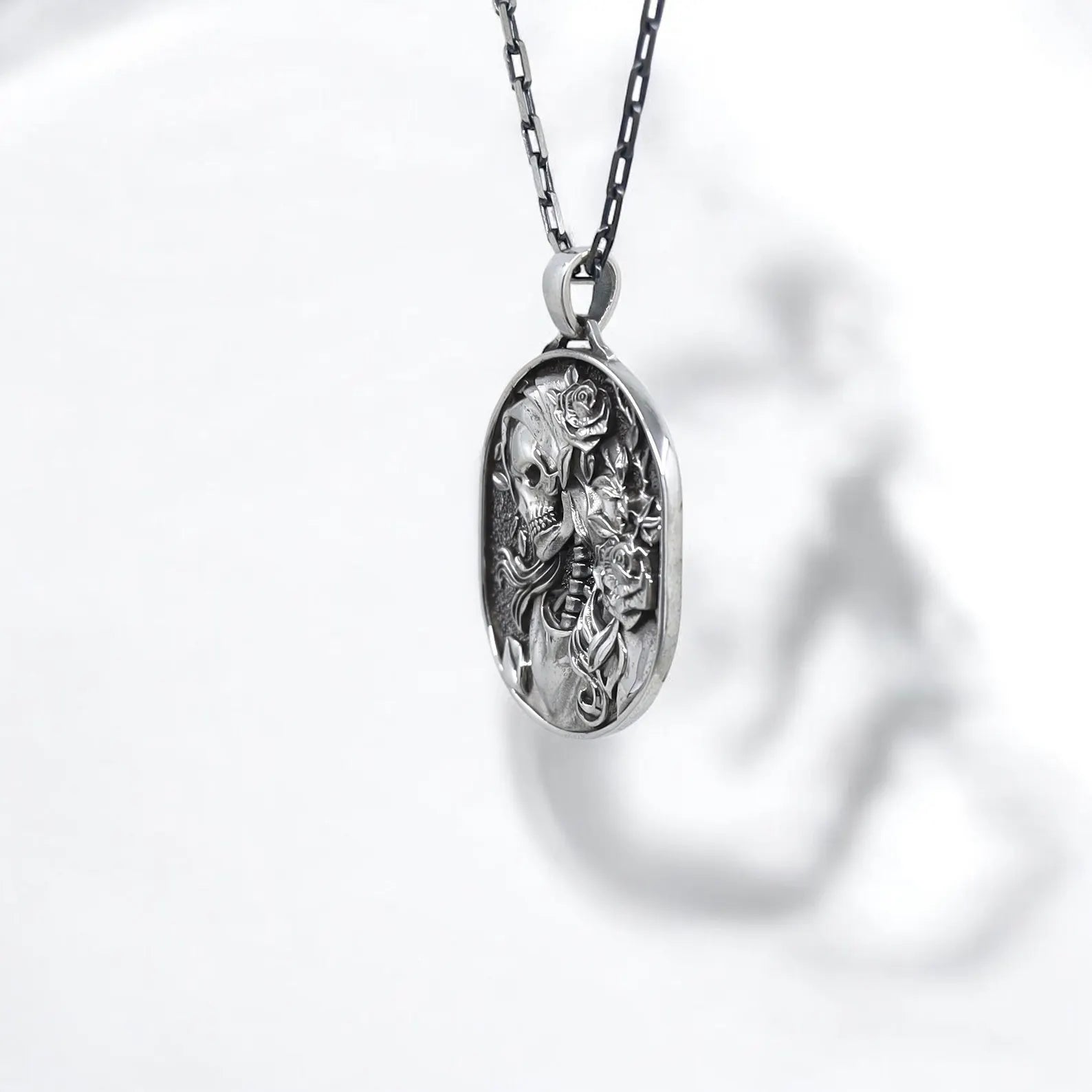 Detailed skeleton cameo pendant necklace in sterling silver, perfect for expressing a dark romantic aesthetic. This floral skull jewelry piece is inspired by gothic traditions and the Day of the Dead, offering a meaningful gift option for anniversaries, birthdays, or personal milestones.