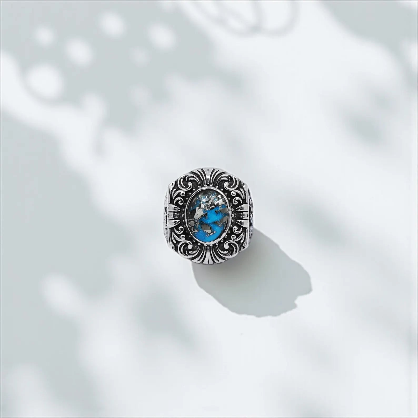 High-resolution artistic shot of a gothic-inspired men's ring with a natural turquoise stone, featuring antique western engravings and a strong masculine style – ideal gift for him.