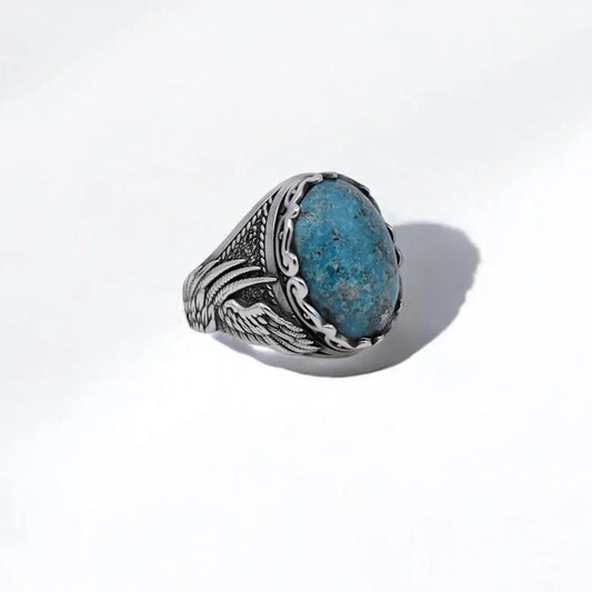 Handcrafted sterling silver turquoise ring for men featuring an intricate wing design and a natural blue stone centerpiece. This tribal-inspired statement ring blends rustic Western style with boho elegance, perfect for ocean souls, bikers, or anyone drawn to bold, meaningful jewelry.