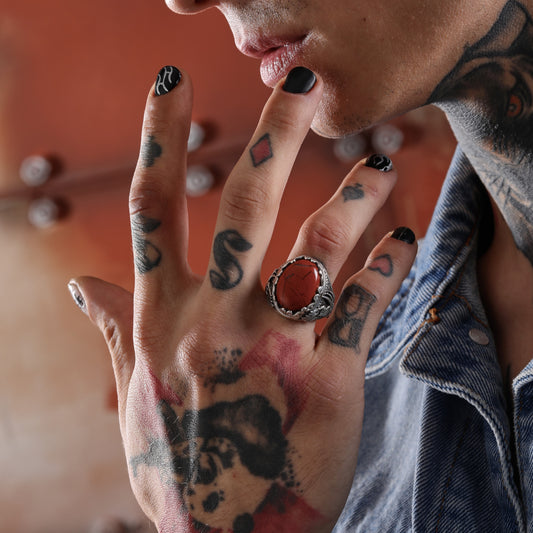 Make a bold statement with our This bold red jasper ring is crafted from high-quality 925 sterling silver and designed with intricate tribal and gothic details. The natural gemstone sits securely within an engraved bezel that evokes the look of ancient warrior rings, blending historic style with contemporary craftsmanship. Whether worn as a fashion piece or a symbolic talisman, this ring is perfect for men
