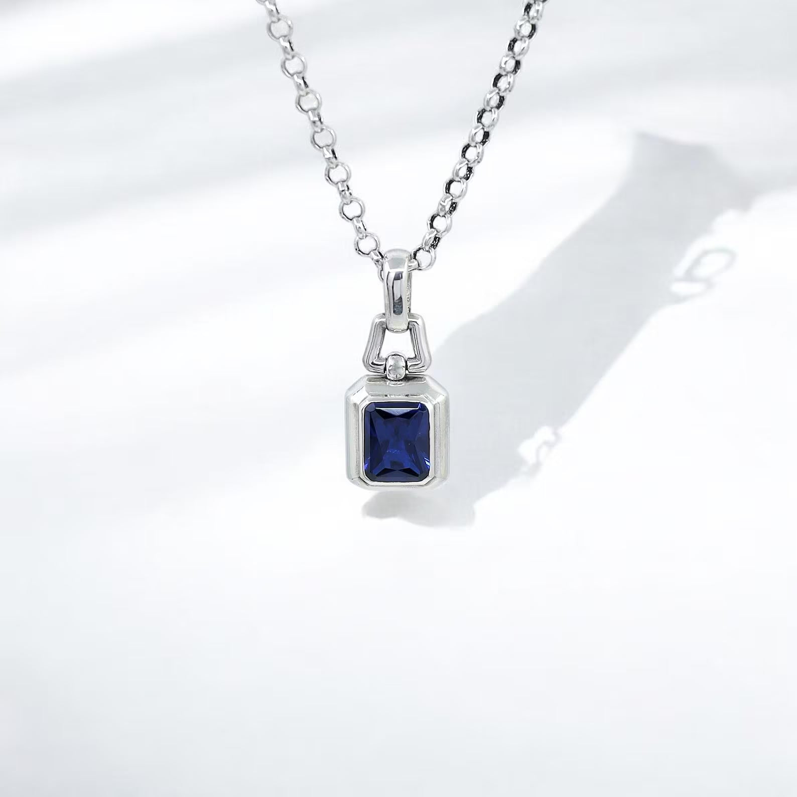 A handcrafted sterling silver necklace featuring a radiant emerald-cut lab sapphire gemstone, blending modern minimalist design with timeless sophistication. This men’s necklace symbolizes elegance, strength, and individuality, making it an ideal accessory for daily wear or meaningful gifting.