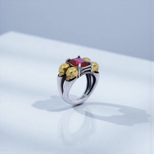 High-resolution close-up of a customizable gothic skull ring featuring a luxurious emerald-cut gemstone set in handcrafted sterling silver with 18K gold plated accents, ideal for searches like emerald skull ring, gothic jewelry men, luxury biker ring.