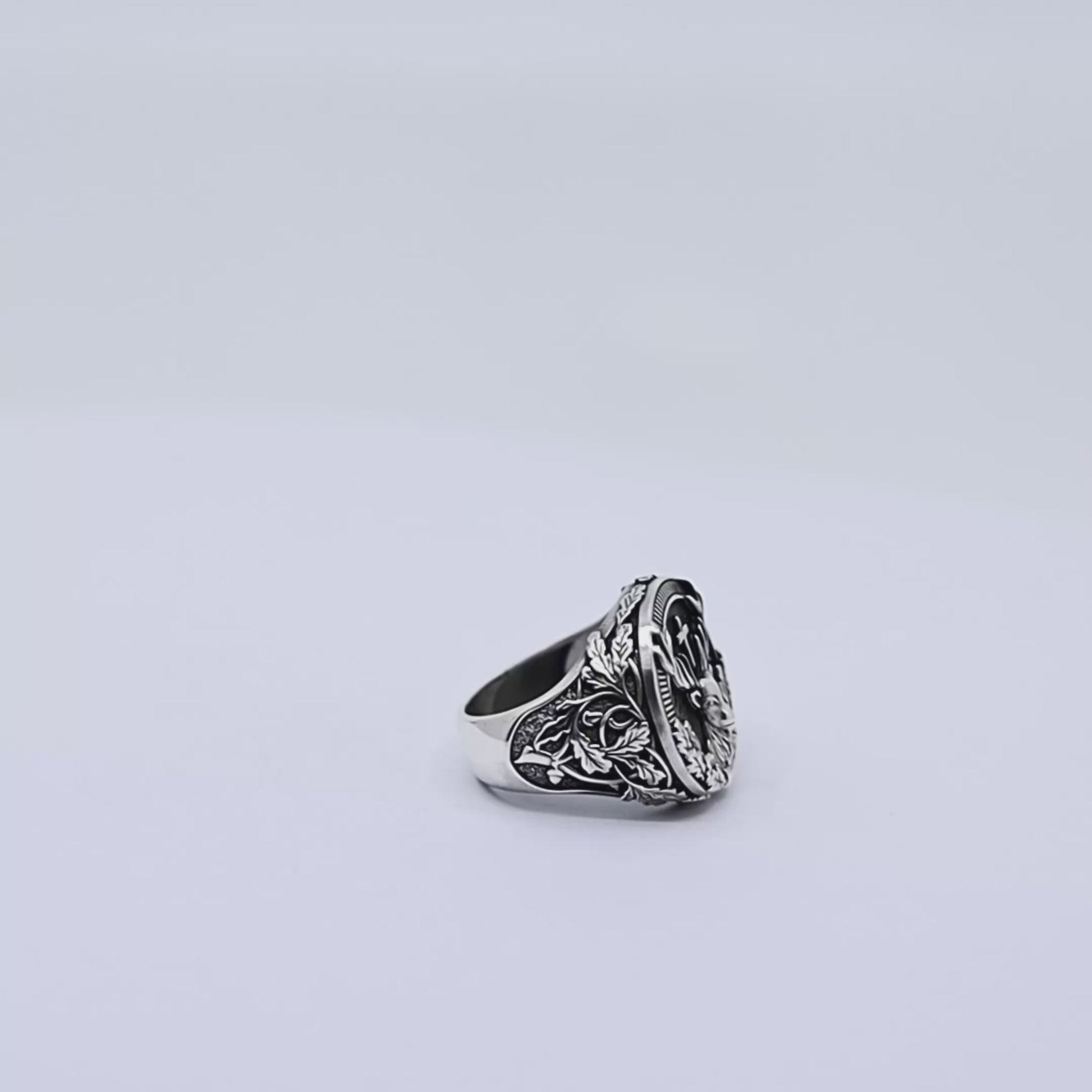 Close-up image of a handcrafted sterling silver deer ring for men, featuring an intricately carved stag head surrounded by gothic-style forest leaves, symbolizing strength, nature, and timeless masculine elegance.