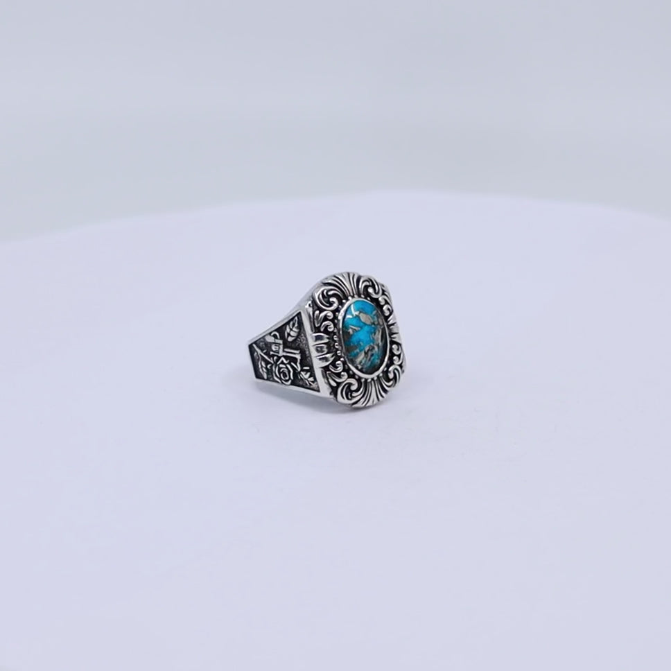 Elegant handmade sterling silver ring for men with deep blue turquoise centerpiece and symbolic rose and revolver side engravings – a perfect blend of boho and outlaw aesthetics.