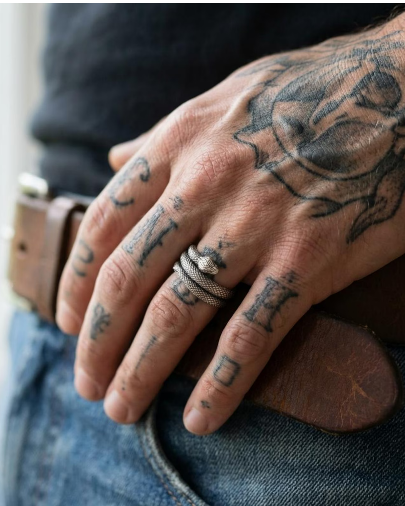 Close-up view of sterling silver serpent wrap ring, gothic snake jewelry with intricate scale texture and oxidized contrast, statement biker ring for men, handcrafted artisan silver jewelry.