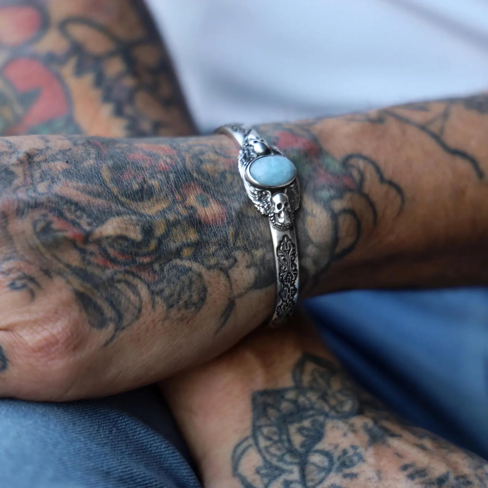 Side profile view of this handcrafted silver aquamarine bracelet for men and women, highlighting the intricate skull design and the calming, protective qualities of the aquamarine birthstone. Perfect for gothic, biker, and alternative fashion lovers, this bracelet is a unique way to combine spiritual symbolism and bold statement style for a look that’s both edgy and deeply personal.