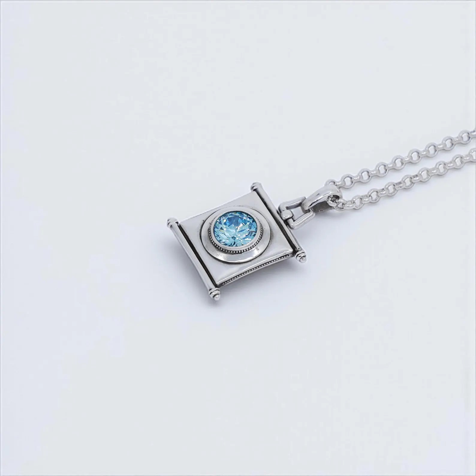 Handcrafted sterling silver pendant necklace featuring a round aquamarine birthstone set in a unique vintage square frame. This timeless piece is ideal for women seeking meaningful handmade jewelry. A perfect March birthstone gift for her on birthdays, anniversaries, or holidays, blending artisan design with symbolic gemstone beauty.