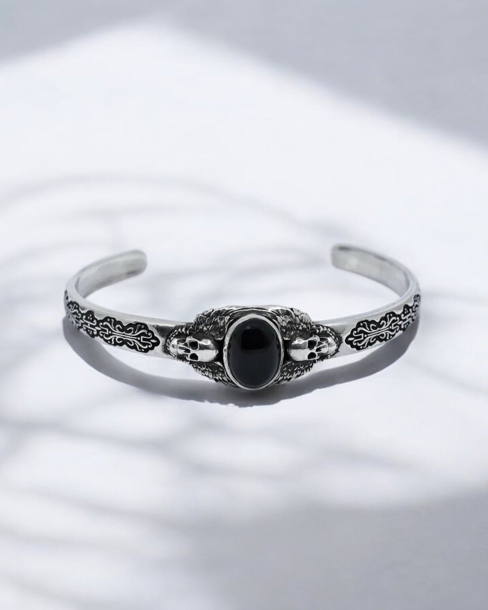 Close-up shot of a handcrafted 925 sterling silver skull bracelet featuring a polished black onyx gemstone. The oxidized silver finish enhances its gothic aesthetic, symbolizing strength, mystery, and individuality. Perfect for men who appreciate luxury handmade biker jewelry and bold accessories.