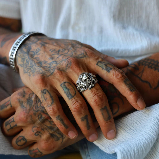 Sterling silver skull ring for men, combining gothic biker style with elegant baroque motifs carved around the band, making it a powerful statement piece for those who embrace dark, detailed, and artistic jewelry.