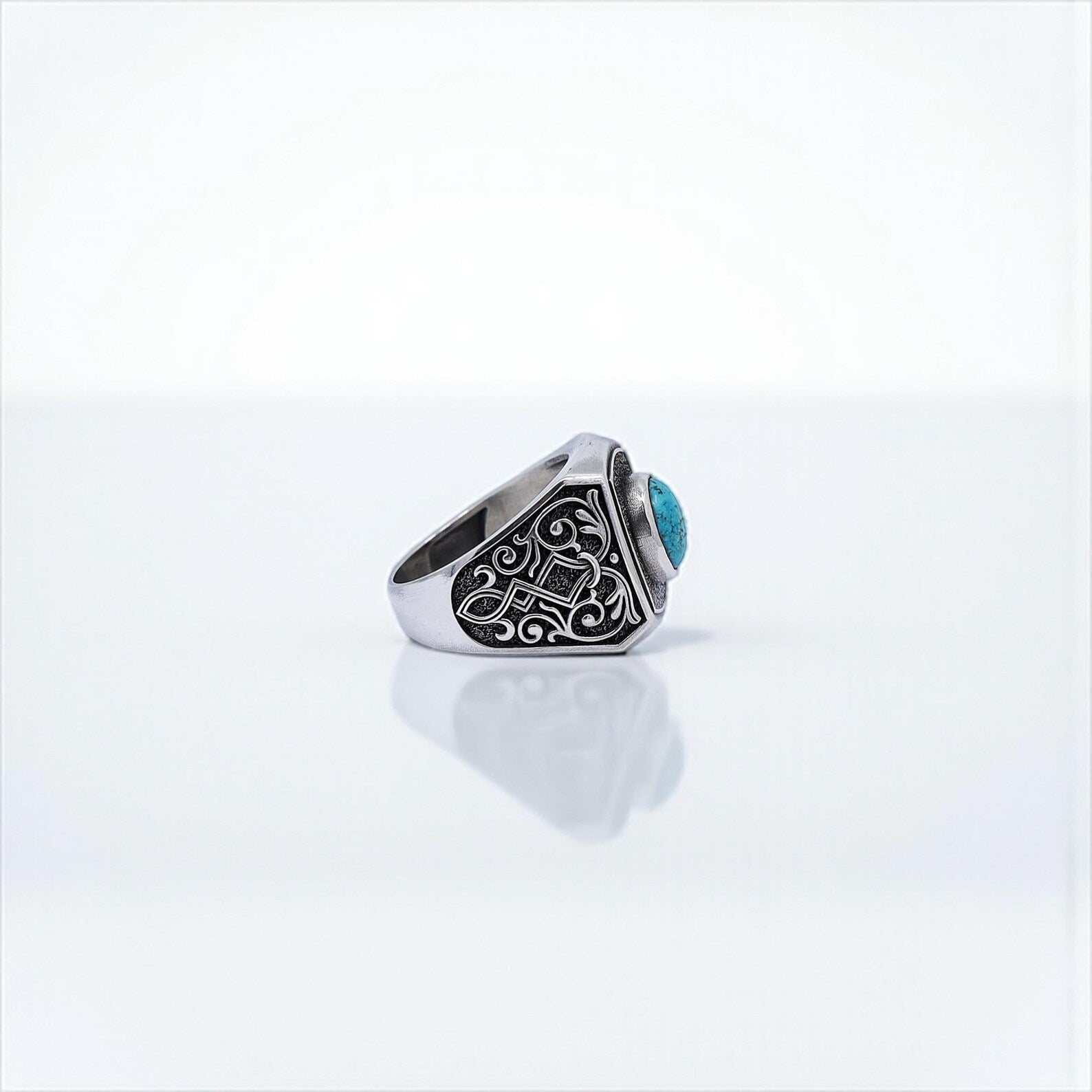 Masculine turquoise ring with tribal carved sides, handcrafted in sterling silver — a gothic boho accessory designed for daily wear or meaningful gifting, radiating individuality and strength.
