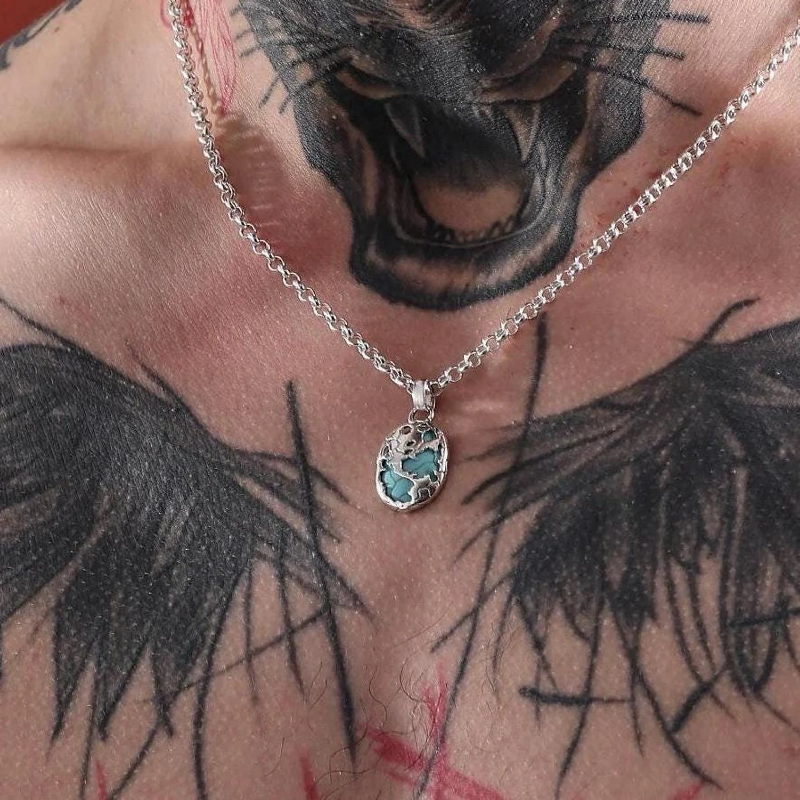 925 sterling silver pendant necklace showcasing a stunning blue turquoise inlay. The intricate handcrafted design reflects a world pattern motif, offering a unique and meaningful accessory that complements both casual and formal looks.