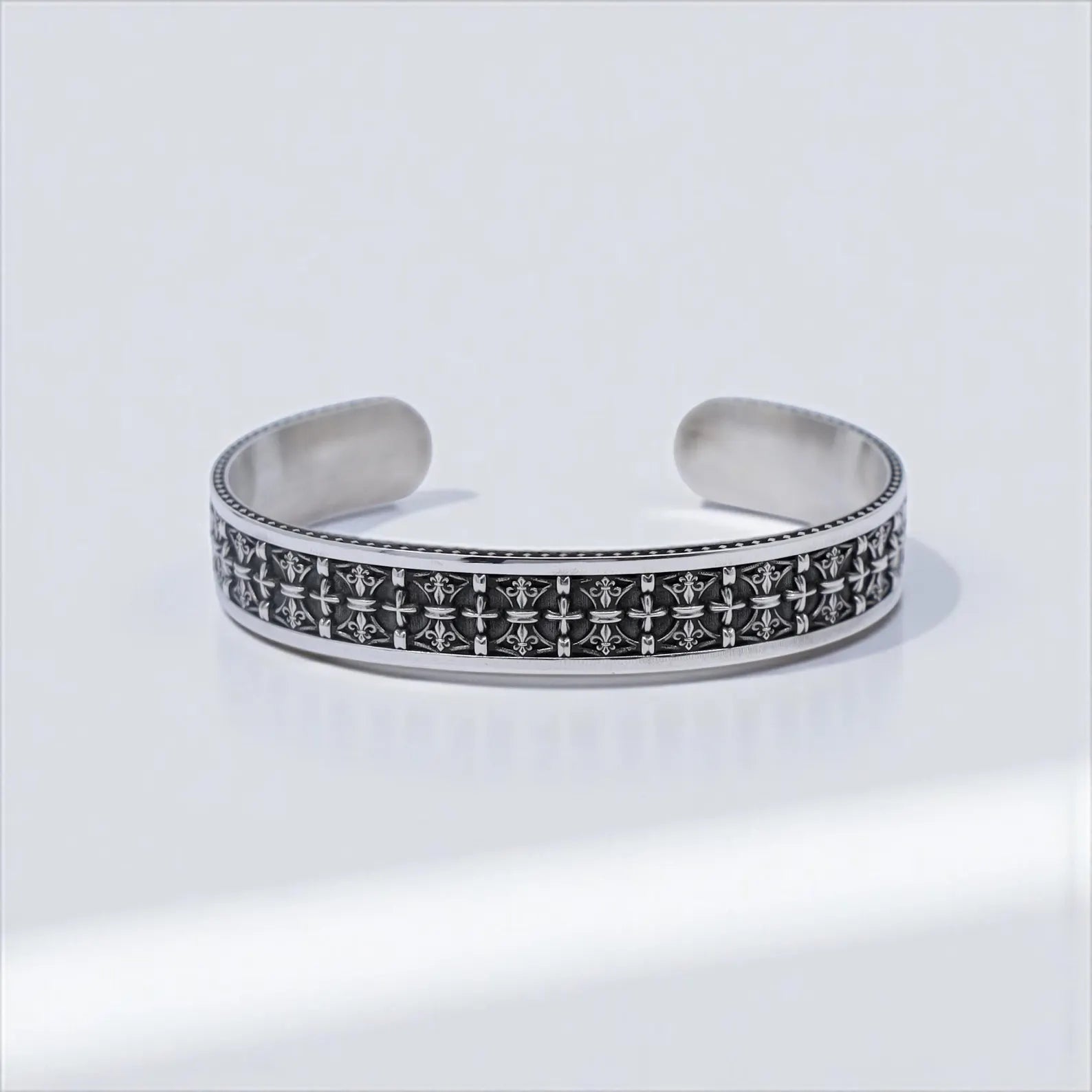 Sterling silver men's cuff bracelet engraved with cross symbols in a repeating gothic pattern, offering both meaning and elegance. This artisan piece is handmade for lasting quality and designed for those who favor a mix of vintage style, faith, and individuality in their jewelry.