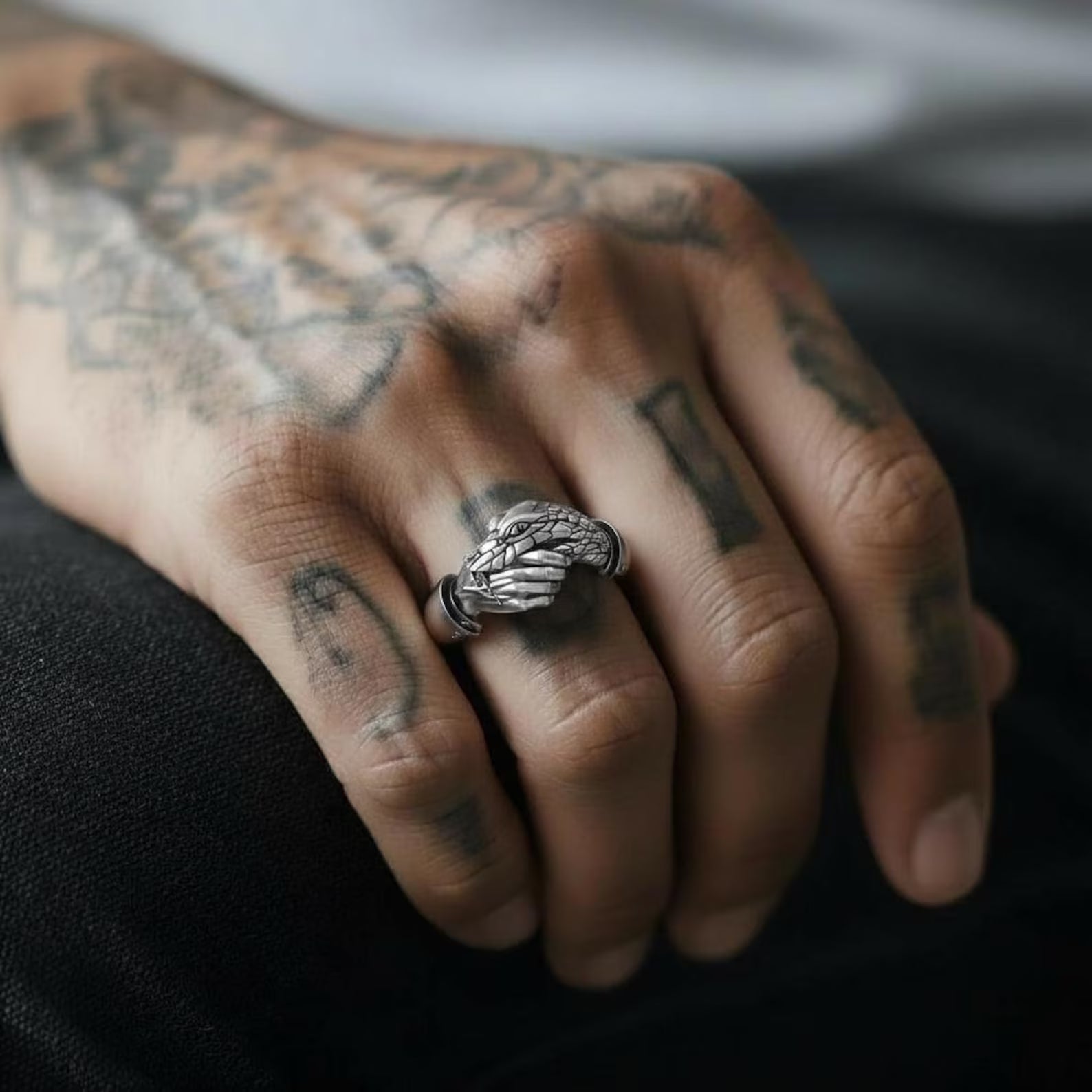 Close-up of a sterling silver Trust No One handshake snake ring showing detailed gothic engravings, serpent texture and hand-finished oxidized surface designed for dark aesthetic and occult jewelry lovers