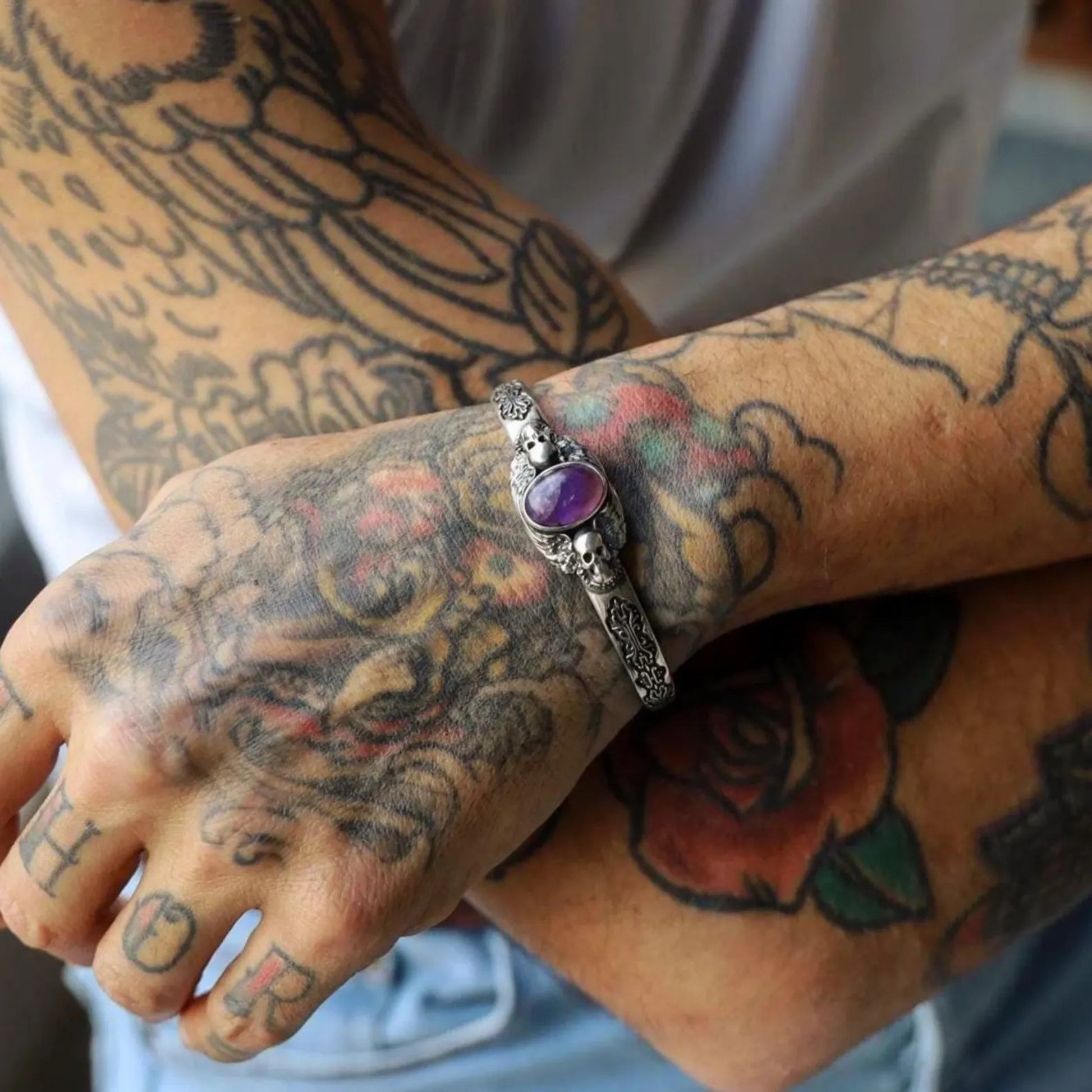 High-quality photo of a gothic skull bracelet in solid sterling silver, featuring a natural purple amethyst gemstone. The handcrafted details and dark oxidized texture give it a mysterious and powerful character, ideal for men’s gothic fashion.