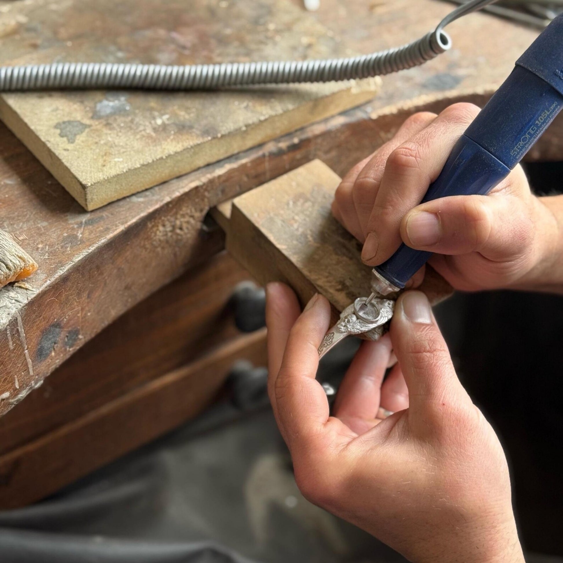 Minimal background image of a handmade silver cuff bracelet featuring a natural black onyx gemstone and twin skulls. Perfectly polished with deep oxidation for contrast — an authentic piece of gothic luxury jewelry.