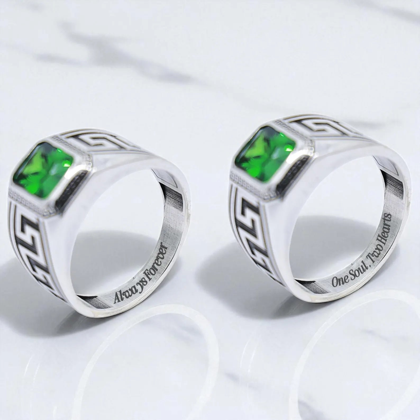 Angled side view of a silver Greek ornament ring with a vibrant green center stone and engraved meander motifs along the band. The clean lines and high-polish finish contrast with the oxidized detailing, highlighting the ring’s timeless craftsmanship and masculine energy.