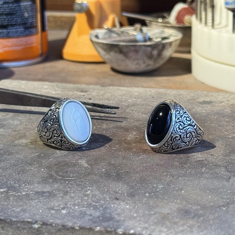 Close-up detail of a Baroque floral turquoise signet ring, showing engraved silver patterns and the natural texture of the turquoise stone