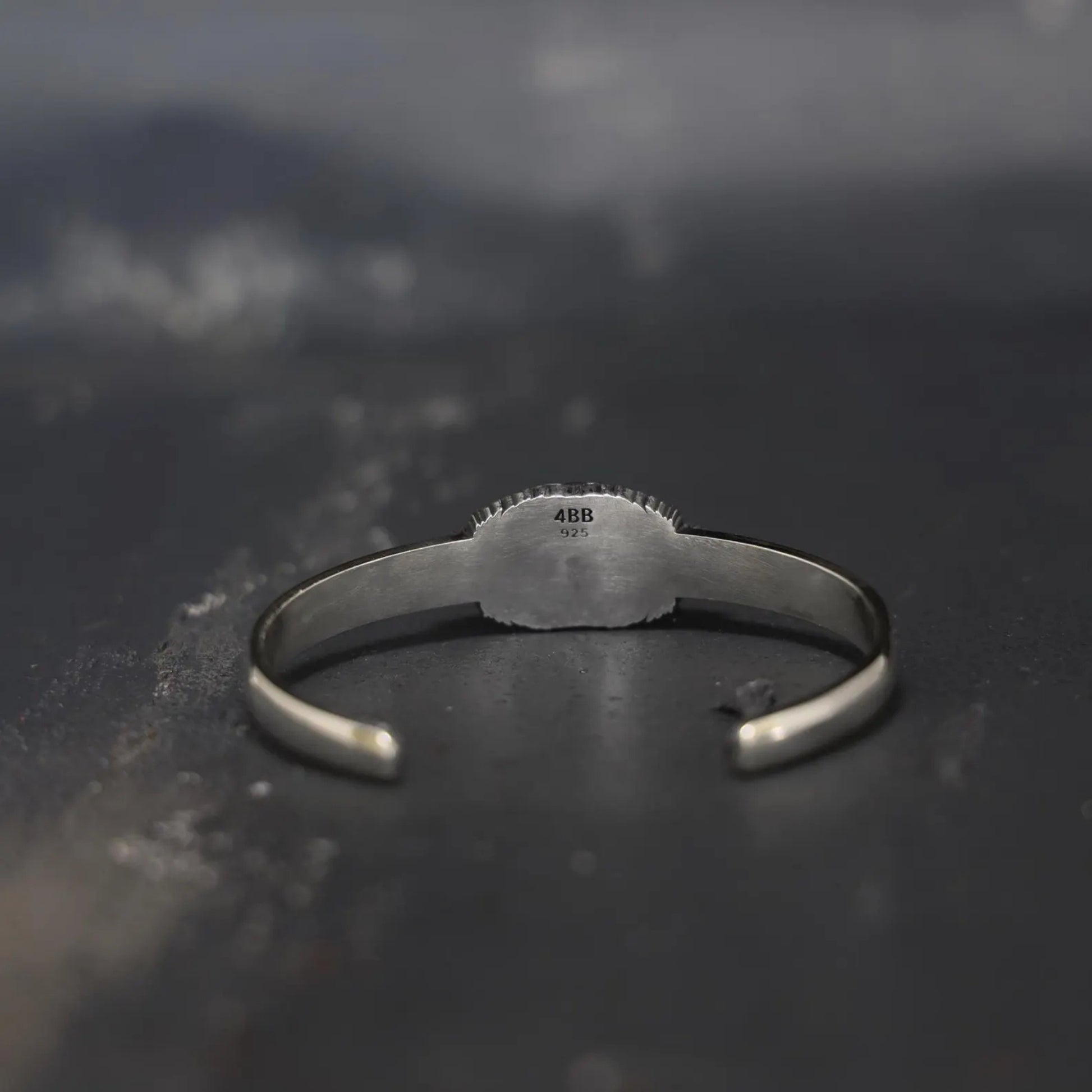 Gothic-inspired sterling silver skull bracelet featuring a deep black onyx stone. The oxidized silver finish and handmade detailing elevate this piece into a symbol of masculine elegance and timeless craftsmanship.