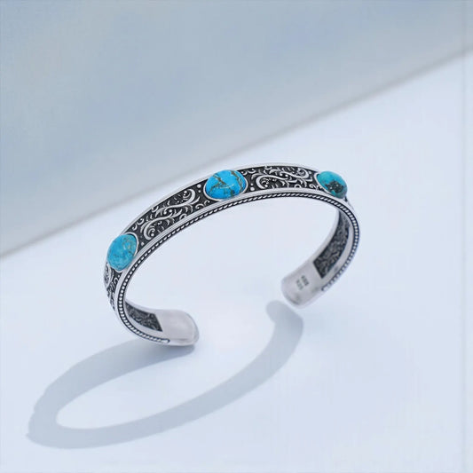 Handmade sterling silver turquoise cuff bracelet with intricate Southwestern engravings, showcasing three vibrant turquoise cabochons on a solid 925 silver band. Unisex bold statement jewelry ideal for bikers, western-style lovers, and anyone seeking a unique, meaningful gift for him.