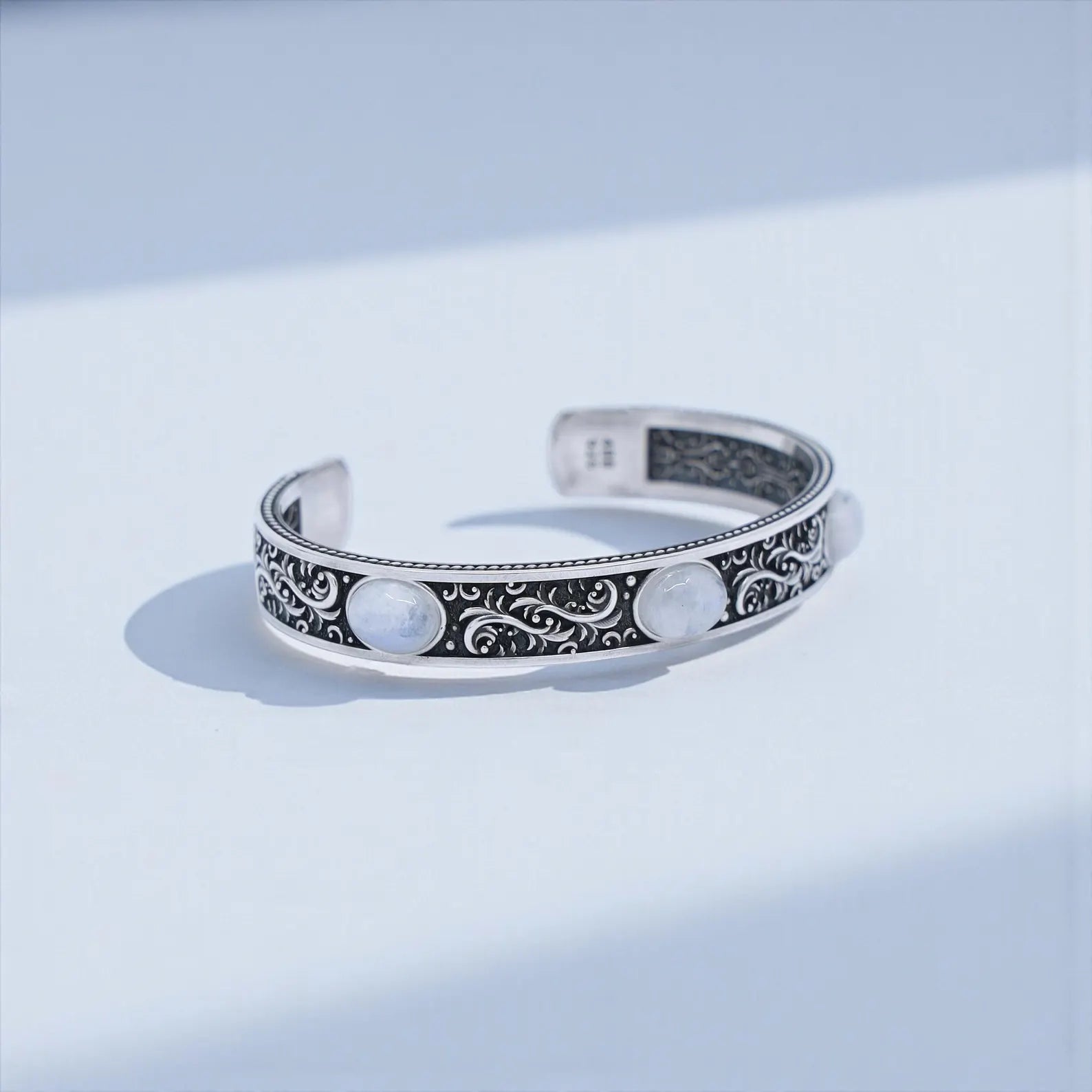 Chunky biker-style moonstone cuff bracelet crafted from solid 925 sterling silver with oxidized vintage Baroque engravings. Features three natural moonstones known for their intuitive and protective energy.