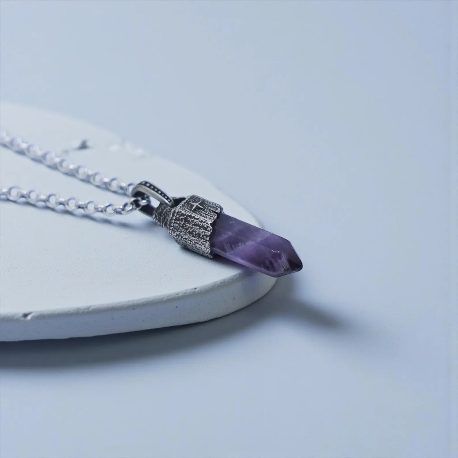 legant lifestyle image of a men’s spiritual amethyst pendant in sterling silver, designed with a nautical theme and vintage detailing, offering calming and protective gemstone energy.