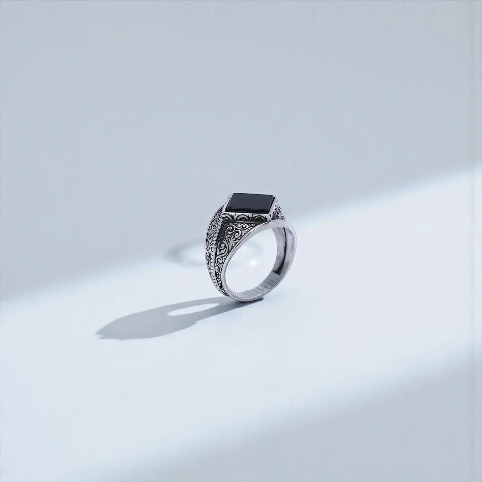 Macro shot of a natural black onyx stone set in a handcrafted 925 sterling silver signet ring for men, highlighting the deep black gemstone and masculine design, suitable for “gemstone ring men” and “sterling silver onyx ring.”