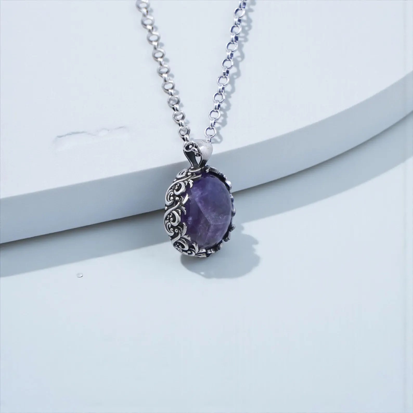 Elegant amethyst gemstone pendant necklace with thick sterling silver frame, bold statement design, handcrafted artistry, and Victorian-inspired detailing, photographed against a clean background for premium jewelry