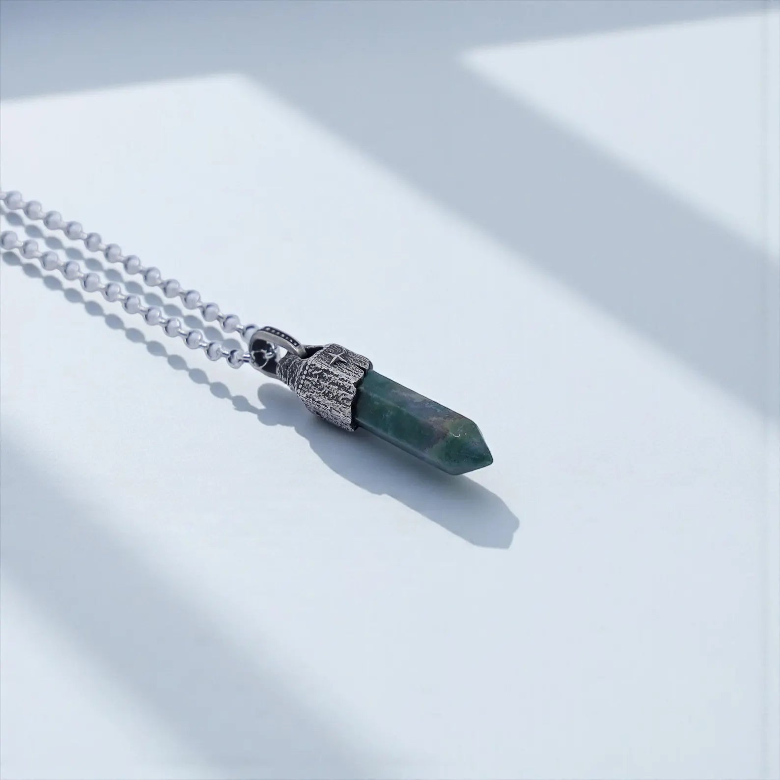 Premium Moss Agate crystal necklace photographed in detail, highlighting the organic green inclusions, 925 sterling silver craftsmanship, and nautical compass-inspired design for men’s statement jewelry.