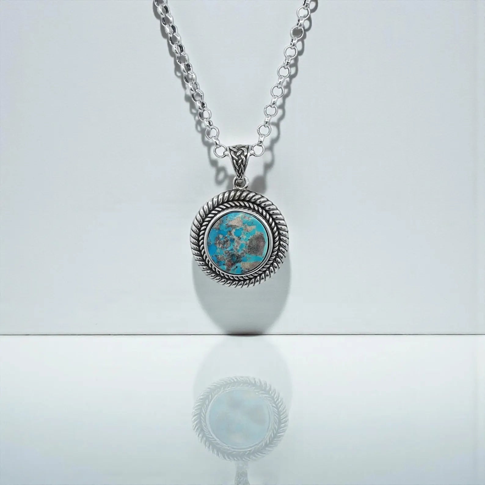 Close-up view of the Southwestern Turquoise Pendant Necklace handcrafted in 925 sterling silver. The vibrant natural turquoise gemstone sits in a bold rope-edge frame, highlighting the rustic Western aesthetic. Perfect for men who love unique, meaningful, artisan gemstone jewelry. A stunning statement necklace and an ideal gift for birthdays, anniversaries, Christmas, or Valentine’s Day.