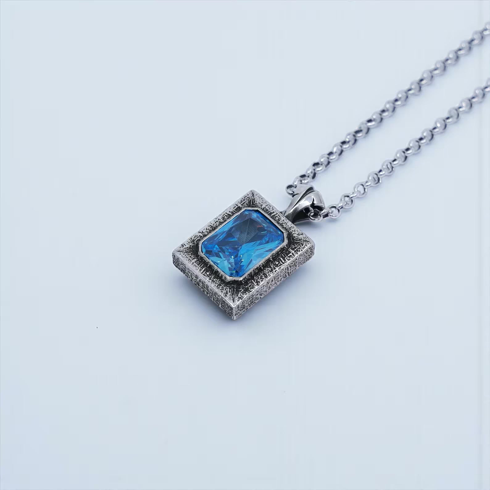 High-quality sterling silver necklace featuring an emerald cut blue topaz gemstone with exceptional clarity and brilliance. The hand-polished finish enhances the luxurious feel of the pendant. A meaningful gift option for anniversaries, holiday celebrations, or romantic occasions such as birthdays for husband or boyfriend.