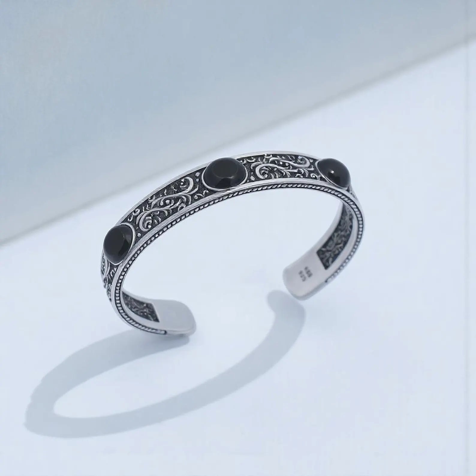 Luxury black onyx cuff bracelet for men with adjustable 150mm sterling silver band, handmade with precision and enhanced with deep engravings, ideal for bikers and bold fashion lovers.