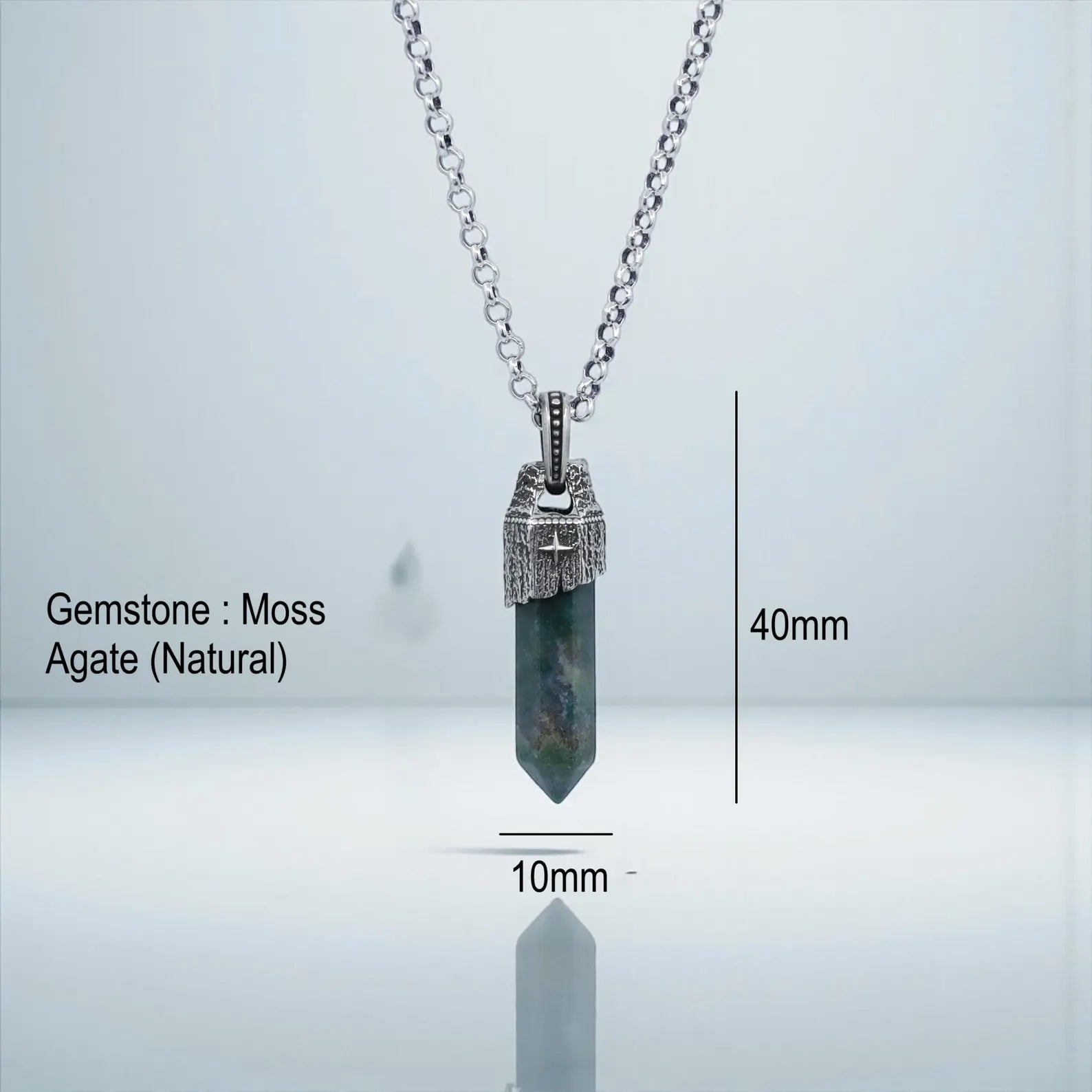 Macro shot of a handcrafted Moss Agate pendant with deep green inclusions, set in oxidized 925 sterling silver compass frame, highlighting the unique natural beauty and vintage elegance of this unisex artisan necklace.