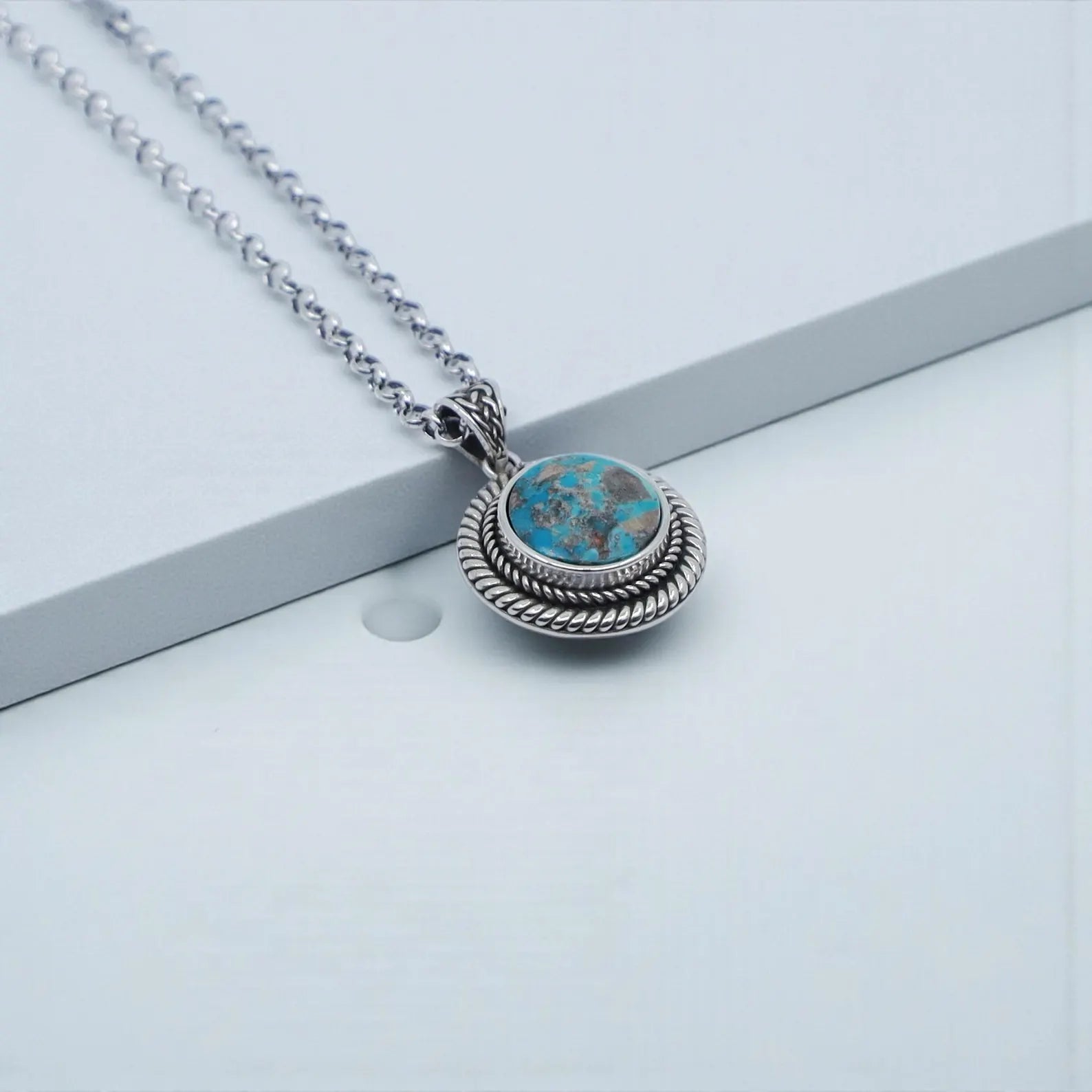 Artistic shot displaying the turquoise pendant paired with a solid 925 sterling silver chain. The oxidized and hand-polished finish creates a vintage-inspired Western look, ideal for men’s minimalist gemstone jewelry. A timeless accessory for everyday wear or special occasions.